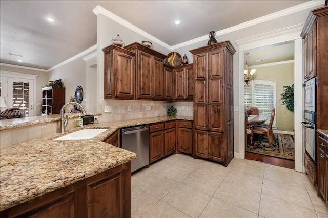 7808 Pineridge Dr, Amarillo, TX 79119 - kitchen featuring a sink, stainless steel appliances, light stone counters, a chandelier, and decorative backsplash