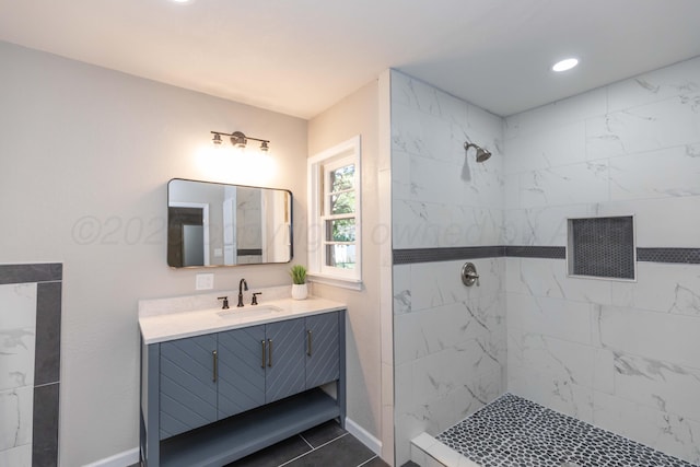 bathroom featuring recessed lighting, baseboards, tiled shower, and vanity