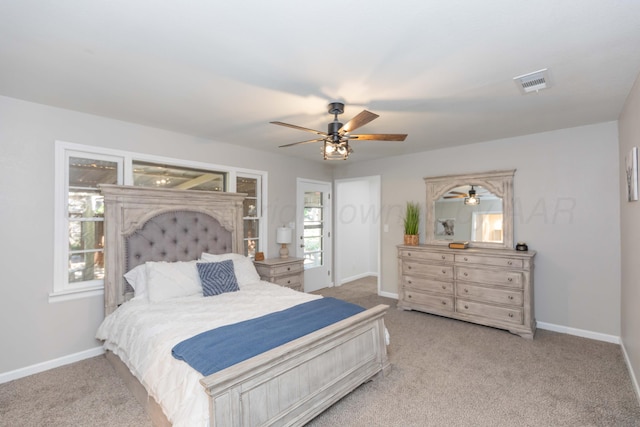 carpeted bedroom with visible vents, baseboards, and ceiling fan