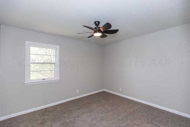 unfurnished room with baseboards, a ceiling fan, and dark carpet