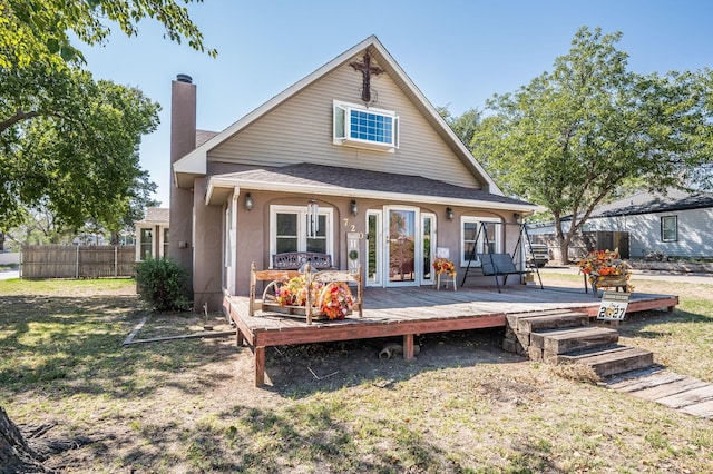 rear view of house featuring a lawn and a deck