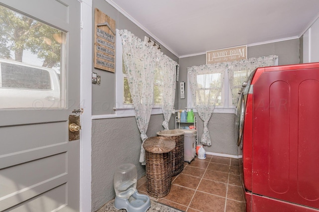 laundry room featuring dark tile patterned floors and ornamental molding