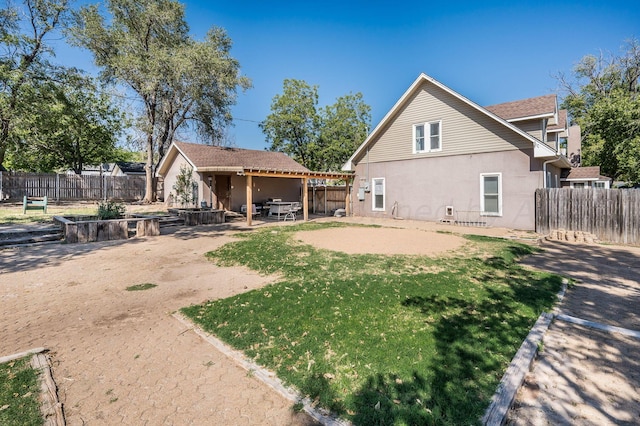 back of house with a lawn and a patio