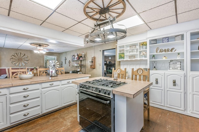 kitchen featuring white cabinetry, black range with gas stovetop, and tile counters