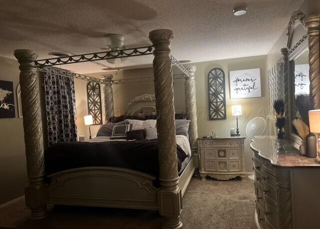 bedroom with a textured ceiling and carpet