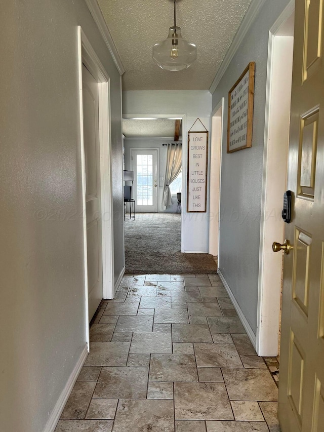 hall with a textured ceiling, light colored carpet, and crown molding