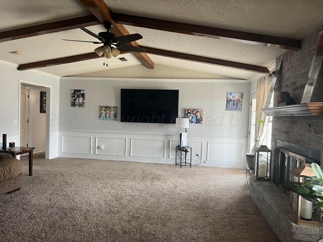 living room with beamed ceiling, carpet flooring, ceiling fan, and a fireplace