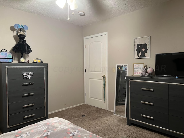 carpeted bedroom featuring a textured ceiling and ceiling fan