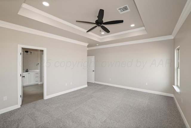 unfurnished bedroom featuring visible vents, carpet, ornamental molding, and a raised ceiling