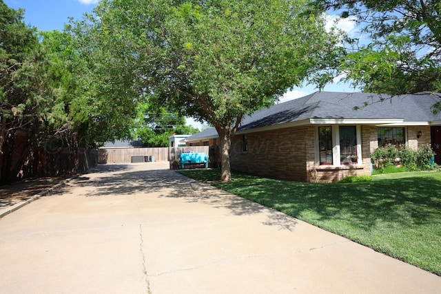 210 Ranger St, Hereford, TX 79045 - view of side of home with concrete driveway, brick siding, and roof with shingles