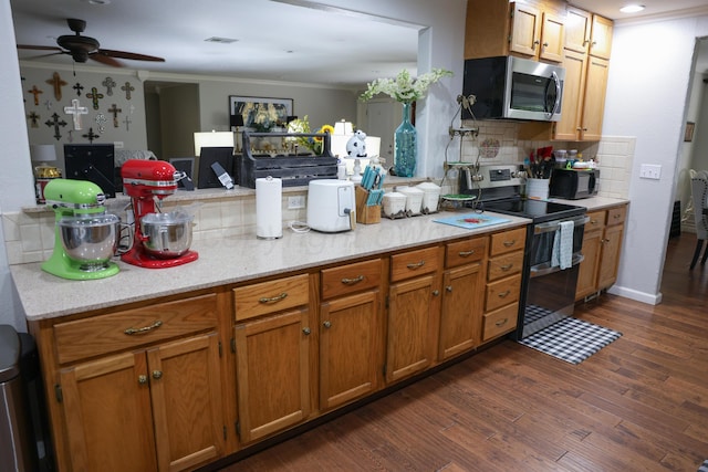 210 Ranger St, Hereford, TX 79045 - kitchen featuring appliances with stainless steel finishes, backsplash, dark wood-style flooring, brown cabinetry, and crown molding