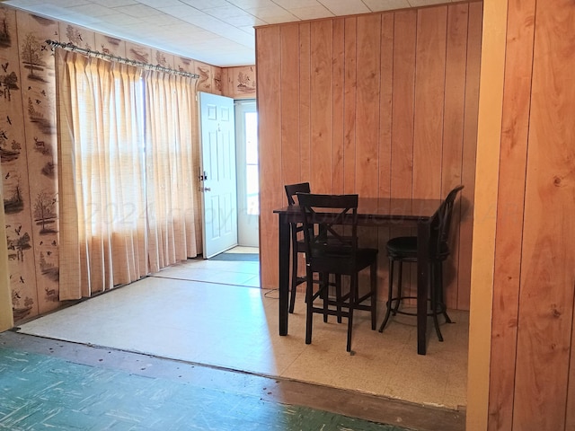 dining area with a wealth of natural light and wooden walls