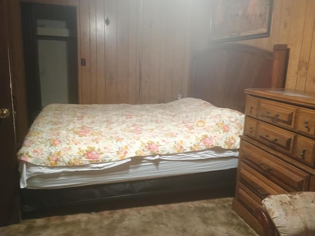 bedroom featuring wood walls, carpet, and a closet