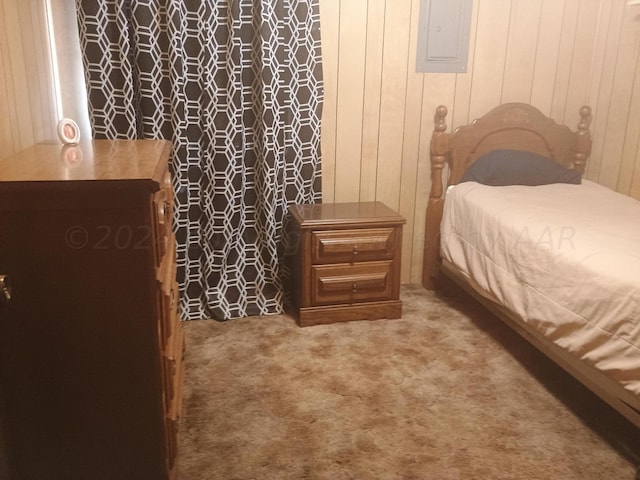carpeted bedroom featuring electric panel and wooden walls