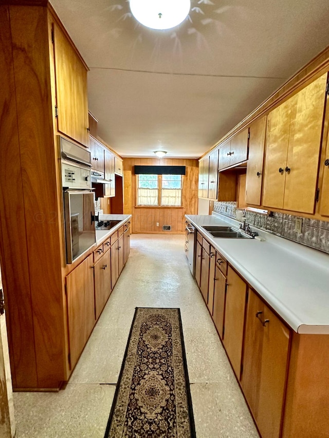 kitchen featuring exhaust hood, wall oven, sink, stainless steel dishwasher, and white cooktop