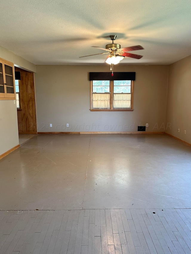 empty room with a textured ceiling and ceiling fan