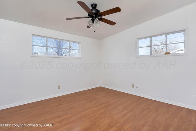 spare room with baseboards, ceiling fan, and wood finished floors