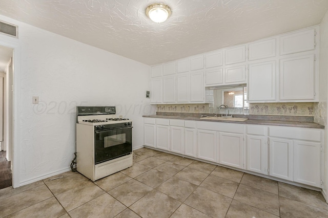 4004 S Van Buren St, Amarillo, TX 79110 - kitchen featuring white range with gas stovetop, white cabinetry, and light tile patterned flooring