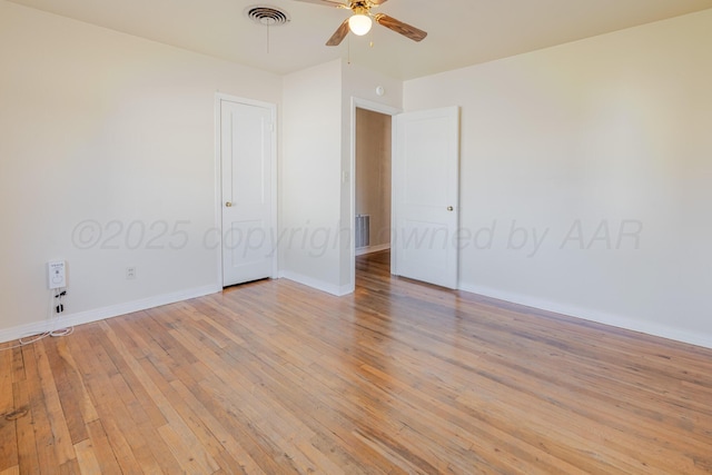 spare room with baseboards, visible vents, light wood-type flooring, and a ceiling fan