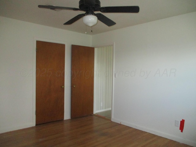unfurnished room featuring wood finished floors, a ceiling fan, and baseboards