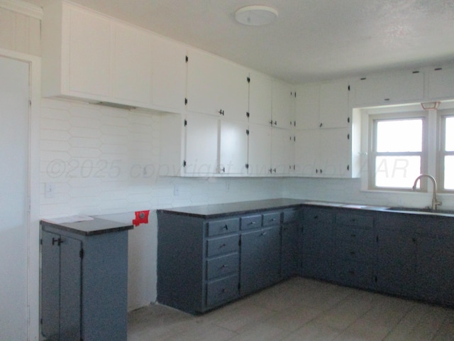 kitchen featuring a sink, tasteful backsplash, and white cabinets