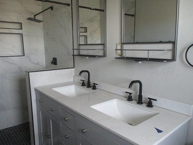 full bathroom with a tile shower and double vanity