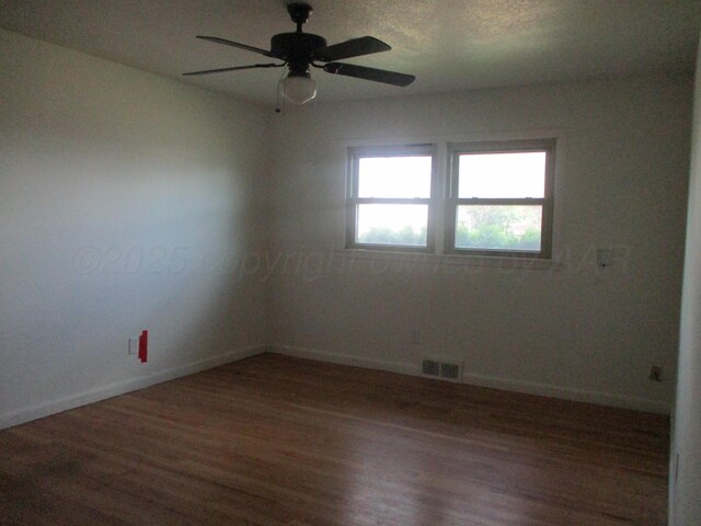 unfurnished room with wood finished floors, baseboards, and ceiling fan