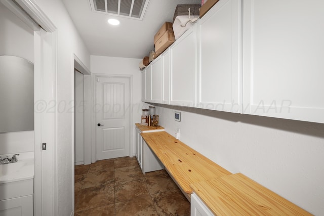 interior space with cabinets, sink, and hookup for a washing machine