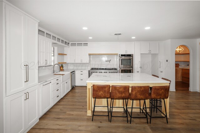 kitchen with white cabinetry, a breakfast bar area, stainless steel appliances, and a center island