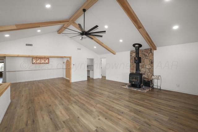 unfurnished living room featuring high vaulted ceiling, beamed ceiling, wood-type flooring, a wood stove, and ceiling fan