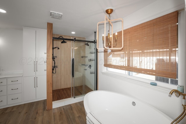 bathroom featuring wood-type flooring and shower with separate bathtub