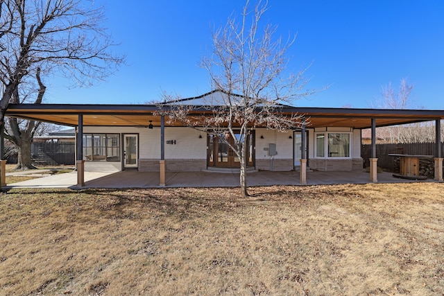 back of house with a yard and a patio