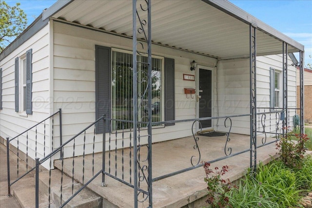 view of exterior entry featuring covered porch