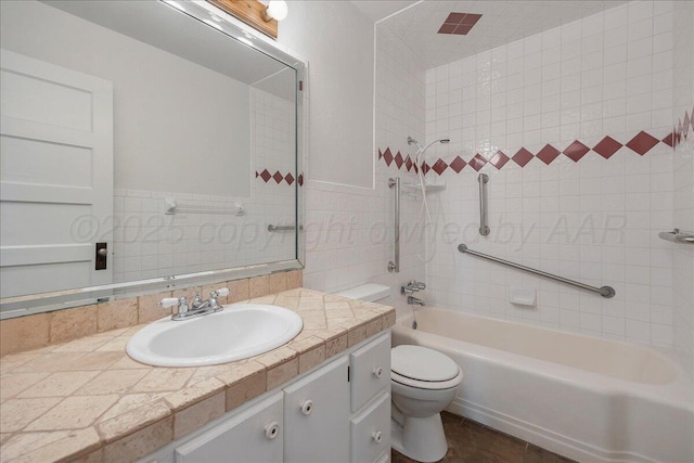 bathroom featuring toilet, bathing tub / shower combination, vanity, and a wainscoted wall