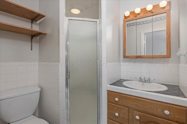 full bathroom with tile walls, toilet, a shower stall, and vanity