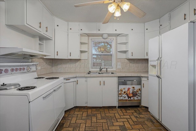kitchen with white appliances, brick patterned floor, open shelves, and a sink