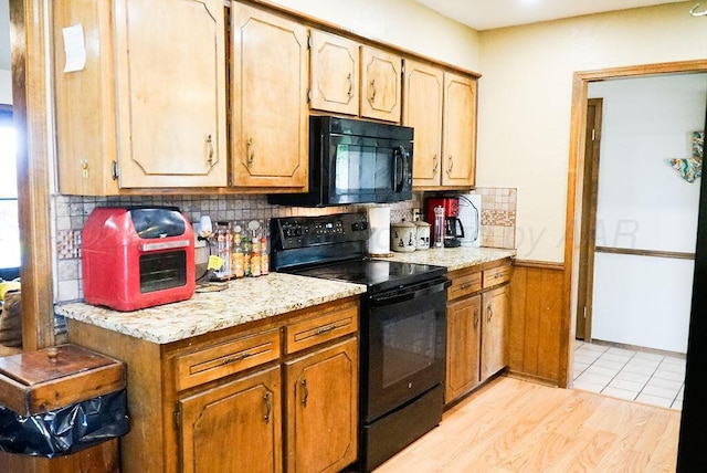 8403 Whittier Dr, Amarillo, TX 79110 - kitchen featuring black appliances, backsplash, a wainscoted wall, and light wood finished floors