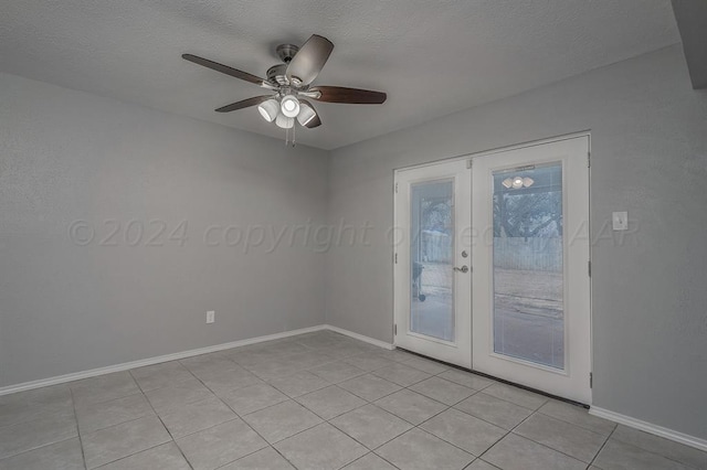 spare room with french doors, a textured ceiling, light tile patterned floors, and ceiling fan