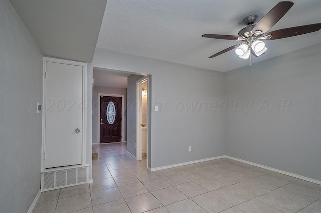 tiled spare room with ceiling fan