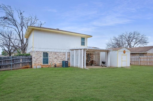 back of property with a lawn, central AC, and a storage unit