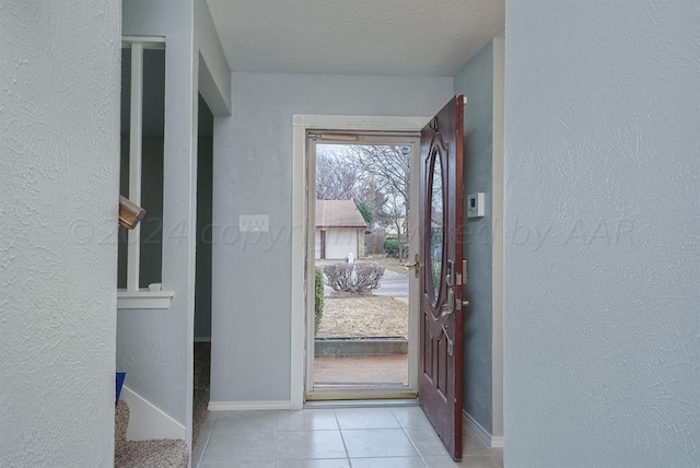 tiled foyer entrance featuring a textured ceiling