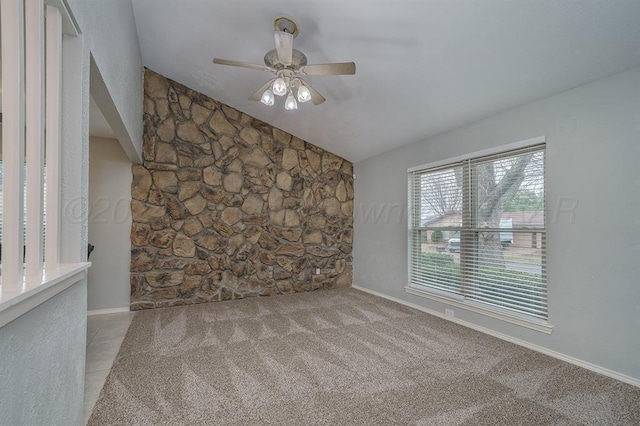 carpeted spare room with ceiling fan and vaulted ceiling