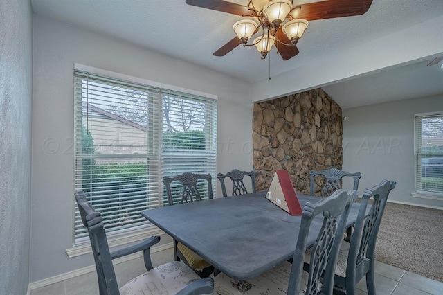 dining space with light tile patterned floors, a textured ceiling, and ceiling fan