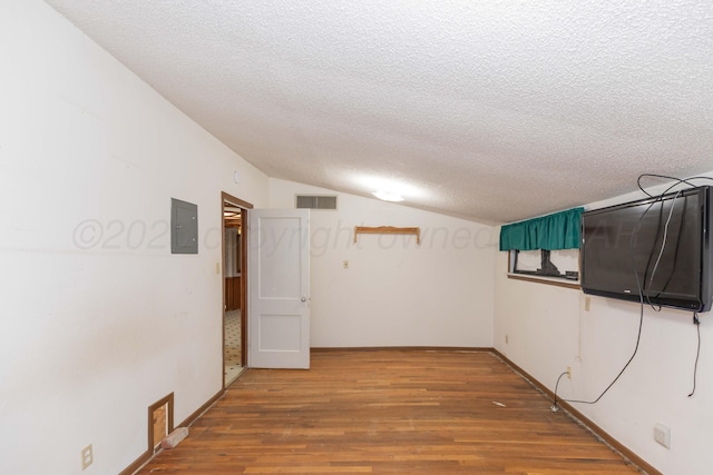 507 Aaron Rd, Fritch, TX 79036 - hall with electric panel, wood finished floors, a textured ceiling, visible vents, and vaulted ceiling
