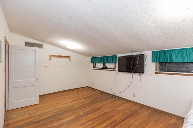 507 Aaron Rd, Fritch, TX 79036 - additional living space with wood finished floors, a textured ceiling, visible vents, baseboards, and vaulted ceiling