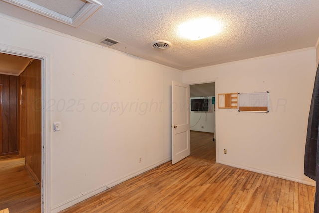 507 Aaron Rd, Fritch, TX 79036 - spare room with light wood-style flooring, a textured ceiling, visible vents, and attic access