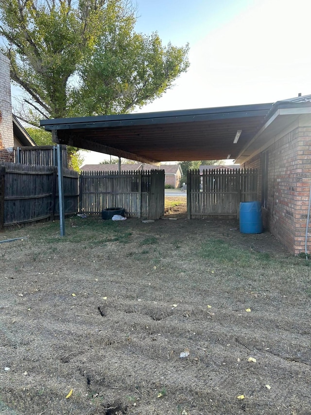 view of parking / parking lot with a carport and fence