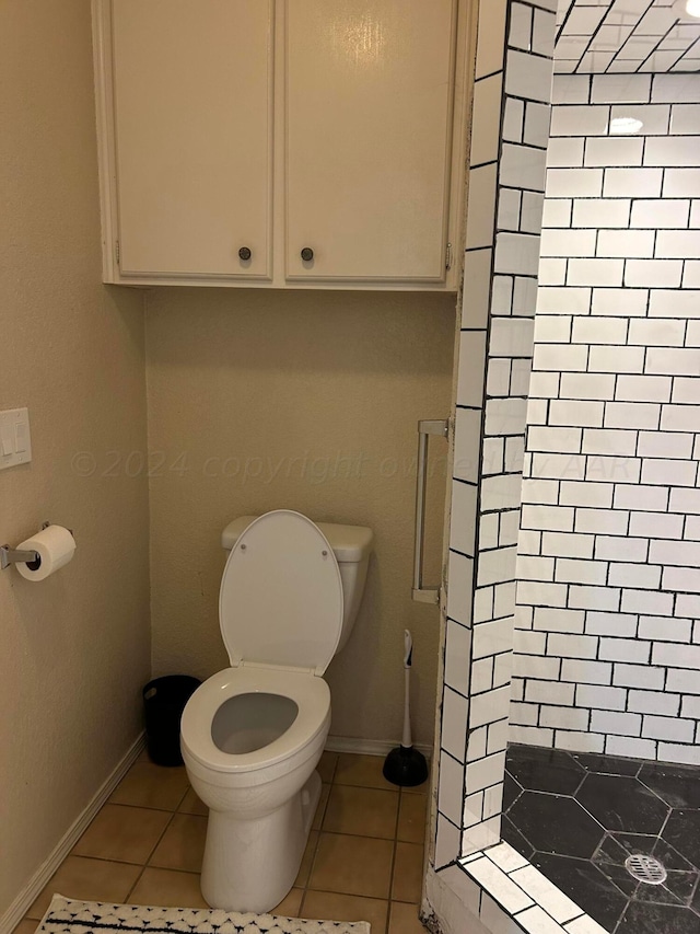 full bathroom with tile patterned flooring, a stall shower, toilet, and baseboards