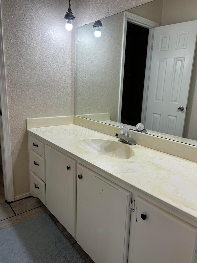 bathroom featuring vanity and a textured wall