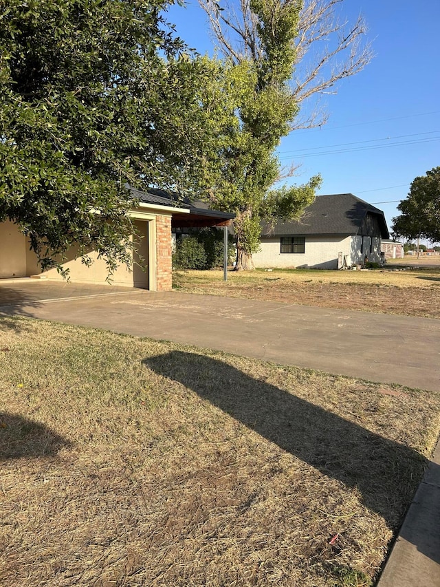 view of yard with an attached garage and concrete driveway